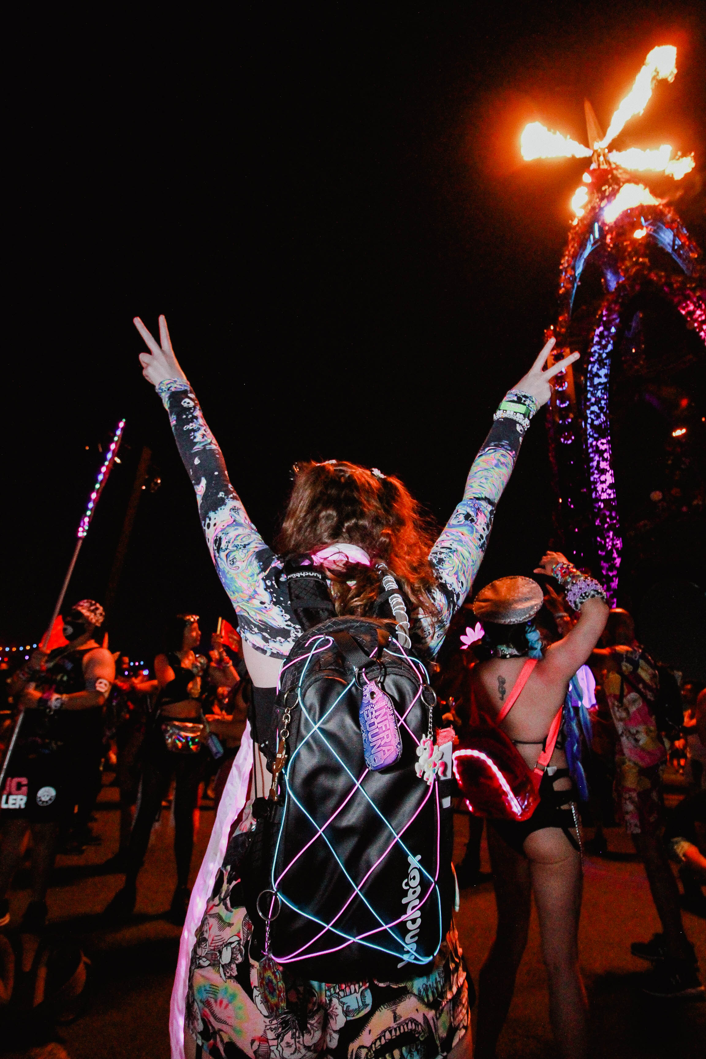 Festival-goer with Lunchbox pack, peace signs up